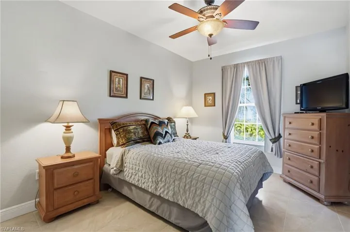 Bedroom with ceiling fan and light tile patterned flooring