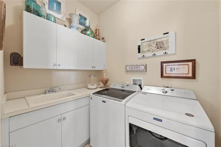 laundry with lots of cabinets and sink