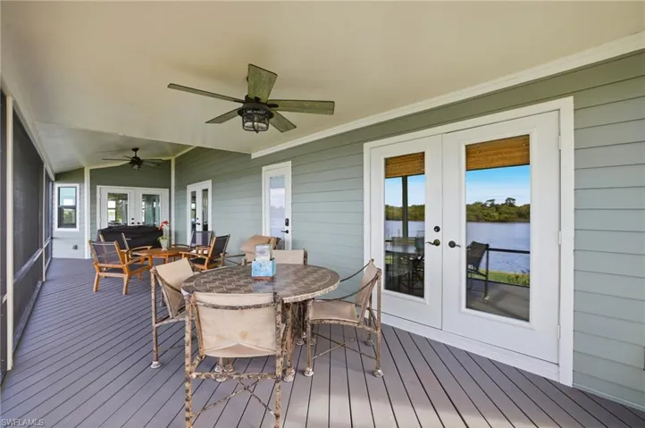 Deck featuring french doors, outdoor dining space, a water view, and ceiling fan