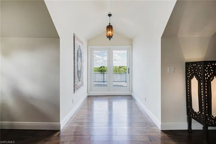 Bedroom with lofted ceiling and wood flooring