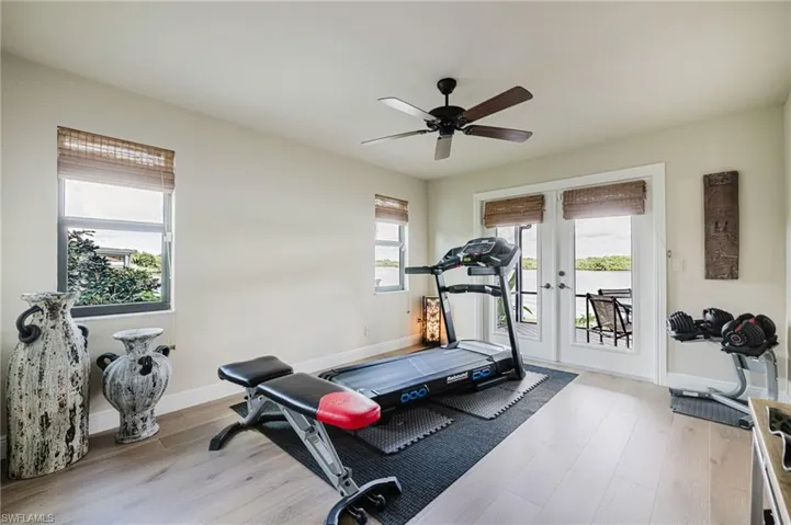 Bedroom featuring light wood flooring, french doors, and a ceiling fan