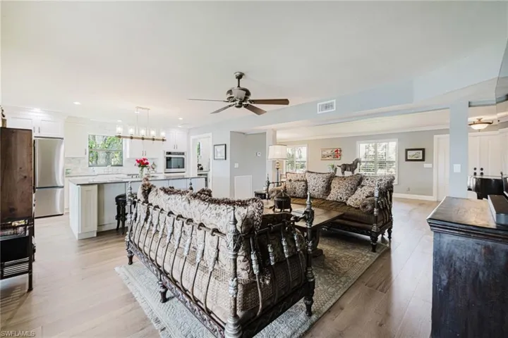 Living area featuring plenty of natural light, light wood finished floors, ceiling fan, and recessed lighting