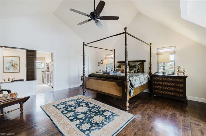 Bedroom featuring high vaulted ceiling, multiple windows, ceiling fan, and dark wood floors