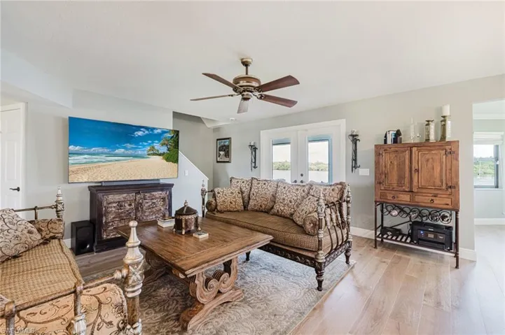 Living room with light wood floors, and ceiling fan