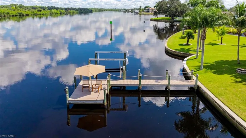 Dock area featuring a river view, a yard, and boat lift