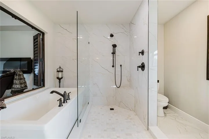 Full bathroom featuring a marble finish shower, a bath, and marble finish flooring