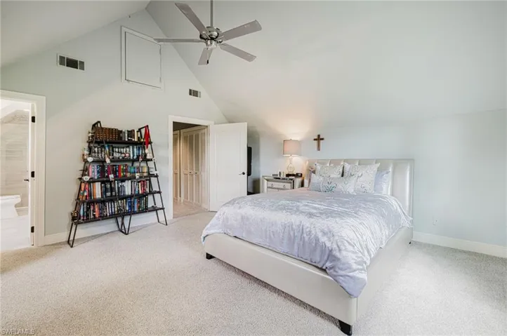 Bedroom featuring high vaulted ceiling, carpet flooring, a ceiling fan, and connected bathroom