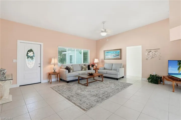 Living area featuring light tile patterned floors and ceiling fan - Vi