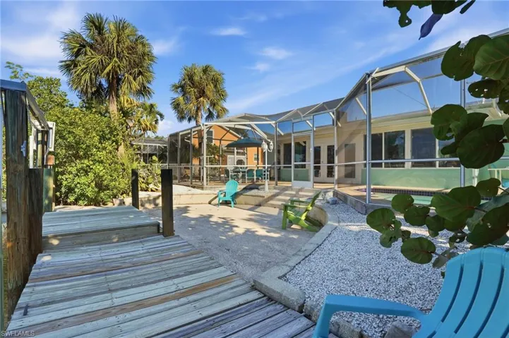 Wooden deck featuring a lanai, a sunroom, and a patio - Virtually Edited Image