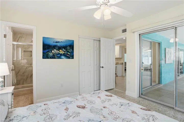 Unfurnished bedroom with access to outside, connected bathroom, a ceiling fan, and a closet - Virtually Edited Image