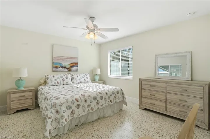 Bedroom with ceiling fan and speckle patterned floor - Virtually Edited Image
