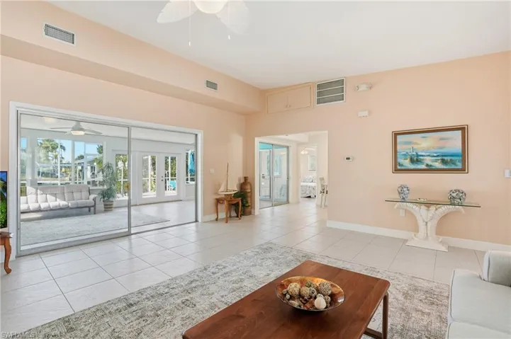 Living area featuring a ceiling fan, light tile patterned floors, and french doors - Virtually Edited Image