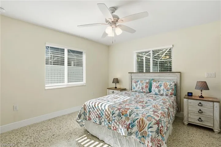 Bedroom featuring speckle patterned floor and ceiling fan - Virtually Edited Image