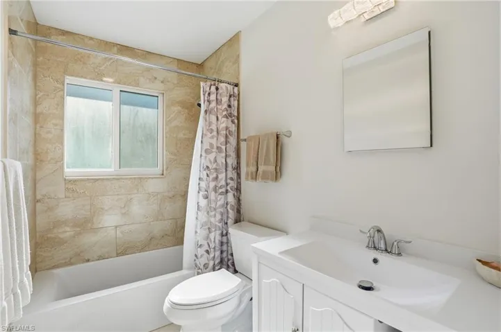 Bathroom with shower / bathtub combination with curtain and vanity - Virtually Edited Image