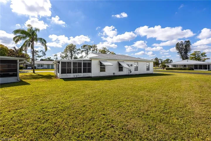 Back of property featuring a yard and a sunroom