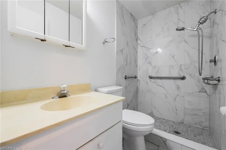 Full bathroom with vanity and a marble finish shower