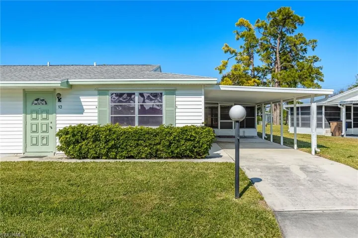 View of front of property featuring a front yard, roof with shingles, and driveway