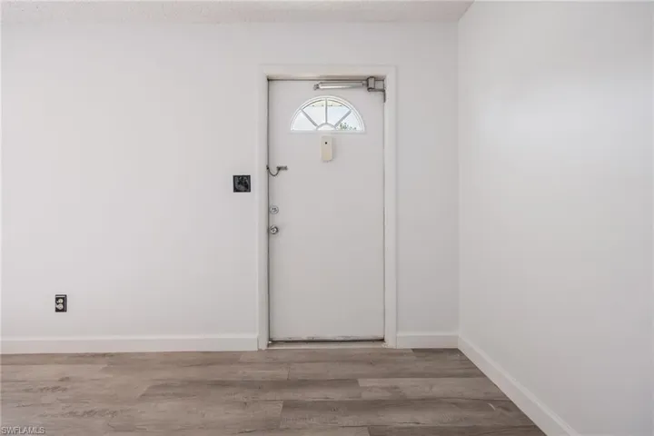 Entrance foyer with wood finished floors and a textured ceiling