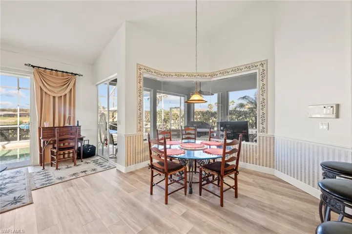 Dining space featuring a wealth of natural light, hardwood / wood-style floors, and high vaulted ceiling