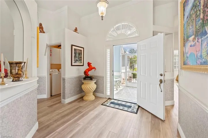 Entrance foyer featuring separate washer and dryer, a towering ceiling, and light wood-type flooring