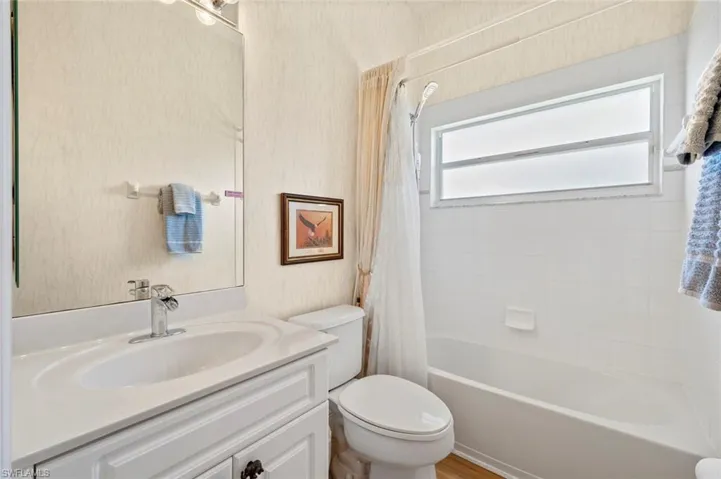 Full bathroom with vanity, toilet, and shower / bath combo with shower curtain