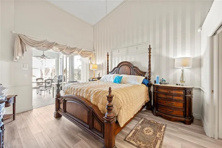 Bedroom featuring high vaulted ceiling, access to exterior, and light hardwood / wood-style floors