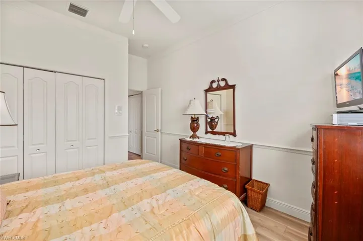Bedroom featuring crown molding, ceiling fan, a closet, and light hardwood / wood-style flooring