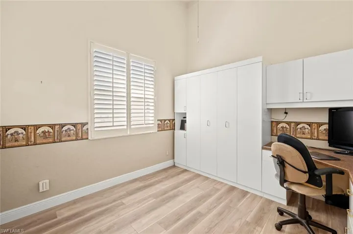 Office area featuring a high ceiling and light wood-type flooring