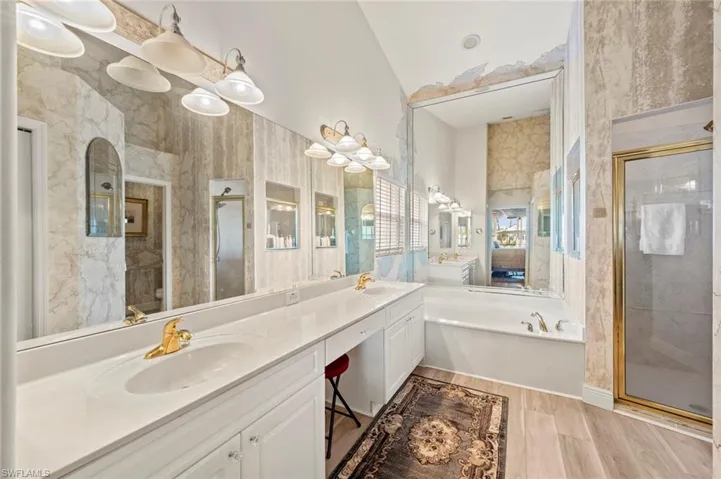 Bathroom with plus walk in shower, lofted ceiling, and vanity
