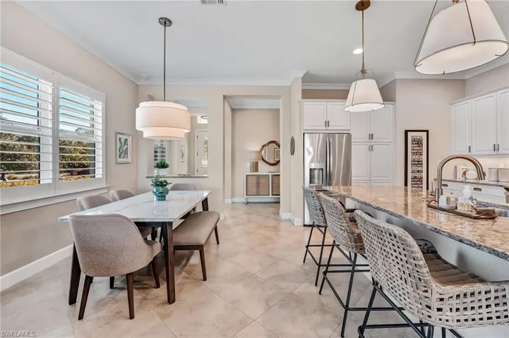 Dining area featuring crown molding and light tile patterned flooring