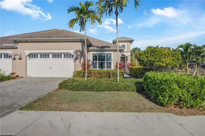 View of front of home with stucco siding, decorative driveway, a garage, and a tiled roof