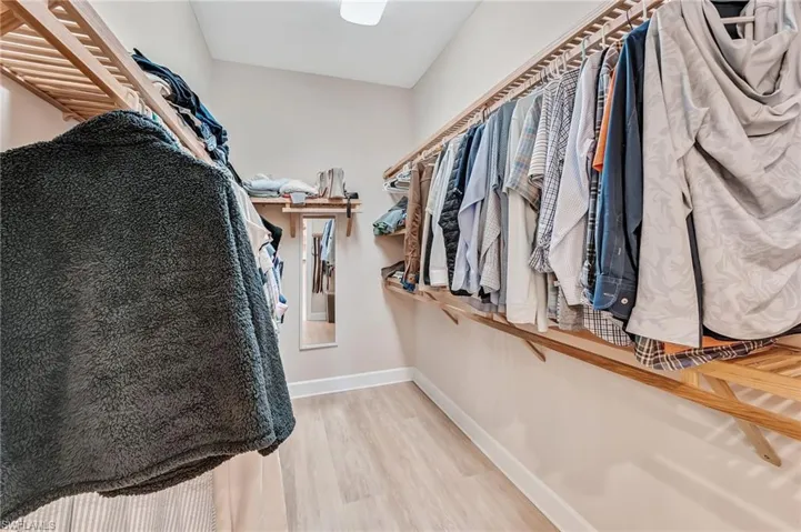 Walk in closet with light wood-style floors