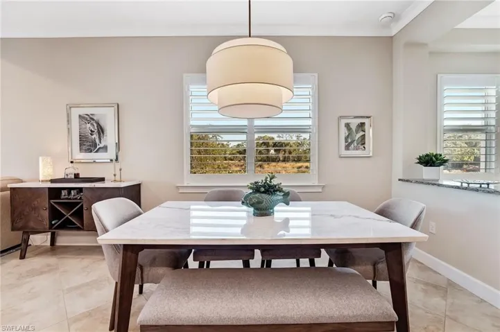 Dining area with healthy amount of natural light, ornamental molding, and light tile patterned flooring