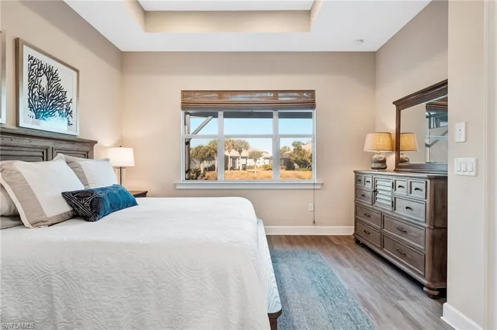 Bedroom featuring light wood finished floors and a tray ceiling