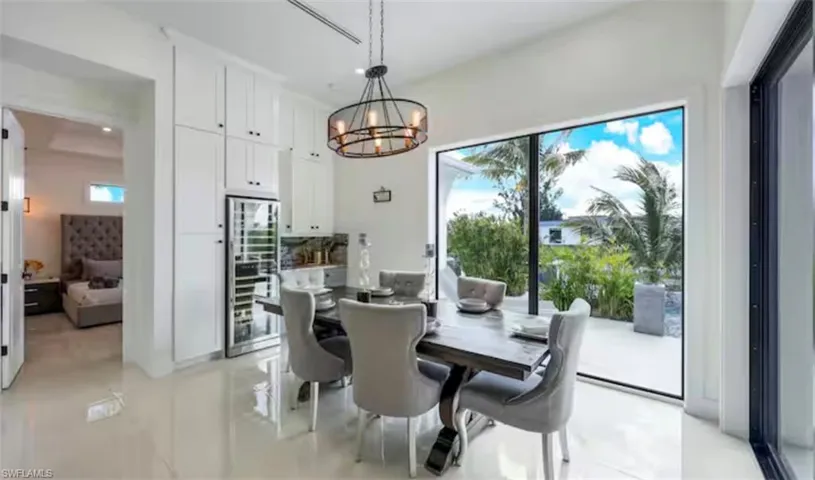 Dining area featuring a chandelier, wine cooler, and light tile patterned floors