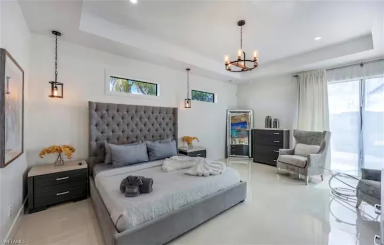 Bedroom featuring a raised ceiling and suspended lighting
