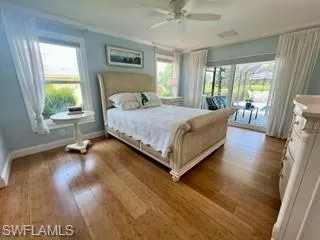 Bedroom featuring access to outside, wood-type flooring, and a ceiling fan