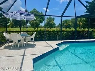 Outdoor pool with glass enclosure, a sunroom, and a patio area