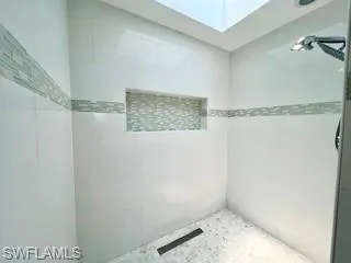 Full bath with a skylight and tiled shower