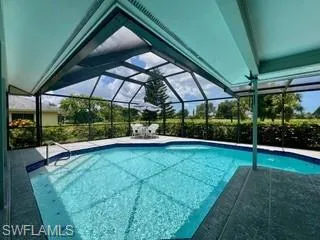 Swimming pool with a patio area, a lanai, and a sunroom