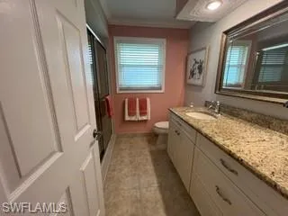 Full bath with vanity, a shower stall, crown molding, light tile patterned floors, and healthy amount of natural light
