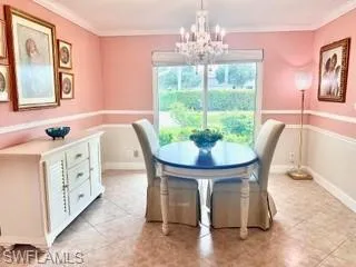 Dining space featuring a chandelier, ornamental molding, and light tile patterned flooring