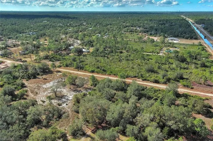 Aerial view of property's location featuring a heavily wooded area