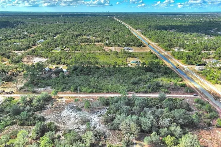 Aerial overview of property's location with a heavily wooded area