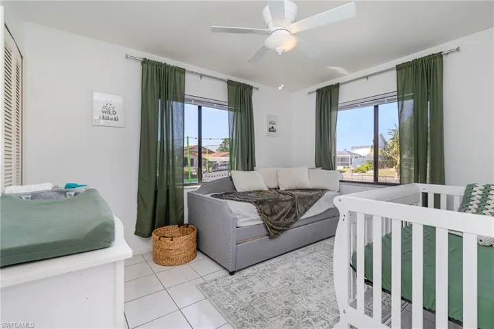 Bedroom with ceiling fan and light tile patterned flooring