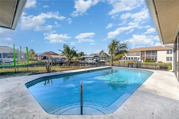 View of swimming pool with a patio area and a trampoline