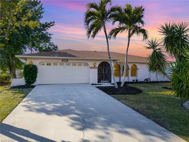 View of front of house with a garage and a lawn