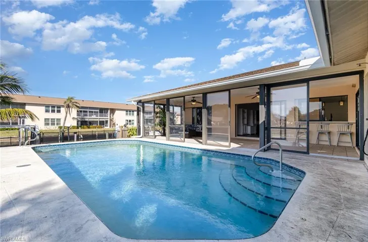 View of swimming pool with ceiling fan and a patio area