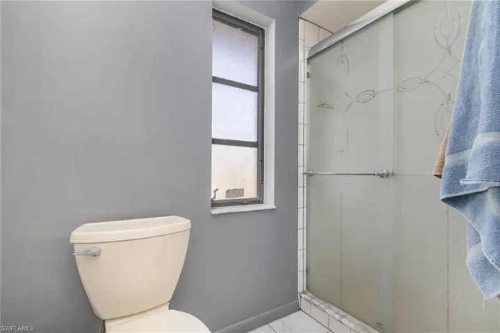 Bathroom with toilet and a shower with shower door