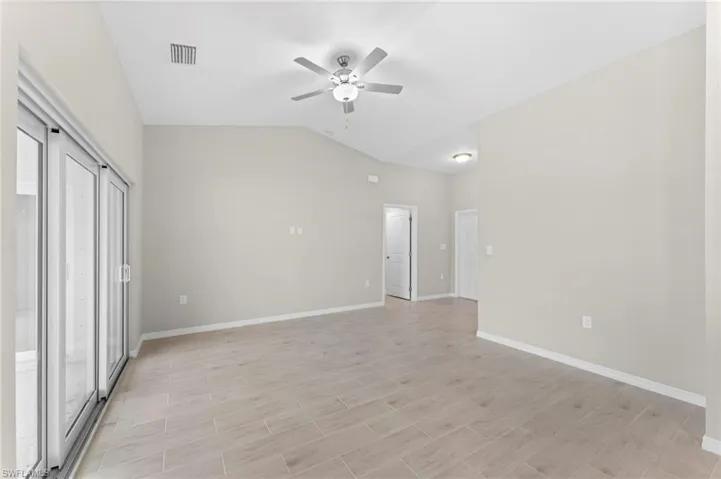 Unfurnished room with ceiling fan and vaulted ceiling